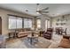 Comfortable living room featuring plush seating, large windows, ceiling fan, and stylish decor at 2939 Crown Bluffs Ct, Las Vegas, NV 89117