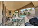Inviting covered patio with outdoor seating and BBQ, overlooking the backyard pool and lush landscaping at 2939 Crown Bluffs Ct, Las Vegas, NV 89117