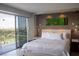 Bright main bedroom boasts balcony access, city views, neutral tones, and pendant bedside lighting at 3111 Bel Air Dr # 15G, Las Vegas, NV 89109