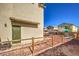 Backyard with green door entry, fencing, and a clear view of the trampoline, dining set, and other homes at 3592 Gloucester Gate St, Las Vegas, NV 89122
