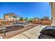 Large backyard featuring a trampoline, dining set with umbrella, and a basketball hoop for recreation at 3592 Gloucester Gate St, Las Vegas, NV 89122