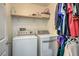 Functional laundry room with modern washer and dryer, storage shelf, and ample space for organizing laundry at 3592 Gloucester Gate St, Las Vegas, NV 89122
