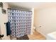 Modern bathroom featuring blue patterned shower curtain, sleek vanity, and wood-look tile flooring at 3789 Heritage Ave, Las Vegas, NV 89121