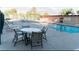 Relaxing poolside area with ample seating around a table, adjacent to a refreshing swimming pool at 3789 Heritage Ave, Las Vegas, NV 89121