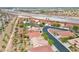 Expansive aerial view of a vibrant community featuring houses with red tiled roofs and lush landscaping near a highway at 4029 Ricebird Way, North Las Vegas, NV 89084
