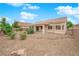 Expansive backyard with desert landscaping, a covered patio, and privacy fencing at 4029 Ricebird Way, North Las Vegas, NV 89084