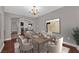 Elegant dining room setup with a chandelier, table setting, and view into the adjacent living room with a fireplace at 4029 Ricebird Way, North Las Vegas, NV 89084