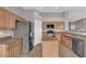 Well-lit kitchen with stainless steel appliances, wood cabinets, and a central island at 4029 Ricebird Way, North Las Vegas, NV 89084