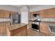 Open kitchen with stainless steel appliances, wood cabinets, and a built-in microwave at 4029 Ricebird Way, North Las Vegas, NV 89084