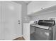 Laundry room equipped with a modern washer and dryer, plus overhead storage cabinets at 4029 Ricebird Way, North Las Vegas, NV 89084