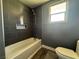 Gray tiled bathroom with a white tub, shower, and decorative shelf at 4732 Illustrious St, Las Vegas, NV 89147