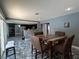 Open dining area with a wooden table set and bar-style seating overlooking the stainless steel kitchen appliances at 4732 Illustrious St, Las Vegas, NV 89147