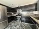Modern kitchen featuring stainless steel appliances and dark cabinets with decorative backsplash and granite countertops at 4732 Illustrious St, Las Vegas, NV 89147