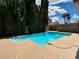 Private pool in a backyard with lounge area and tall trees at 4732 Illustrious St, Las Vegas, NV 89147