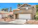 Traditional home features a two-car garage and low-maintenance rock landscaping at 4889 W Montara Cir, Las Vegas, NV 89121
