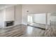 Bright living room featuring gray-washed wood floors, a fireplace, and ample natural light at 4889 W Montara Cir, Las Vegas, NV 89121