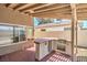An outdoor kitchen features a tile bar and countertop with storage overlooking the back yard at 4889 W Montara Cir, Las Vegas, NV 89121