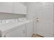 Clean laundry room equipped with a washer, dryer, and overhead storage cabinets at 4924 Cedar Lawn Way, Las Vegas, NV 89130