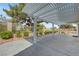 Expansive covered patio surrounded by mature trees and landscaping, providing a tranquil outdoor space at 4924 Cedar Lawn Way, Las Vegas, NV 89130