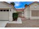 Close up of charming single-story home featuring a two-car garage, desert landscaping, and a classic tile roof at 5124 Appealing Ct, Las Vegas, NV 89130