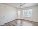 A sunlit bedroom with a ceiling fan, light wood floors, a window, and a glass door to the outside at 5710 E Tropicana Ave # 1017, Las Vegas, NV 89122