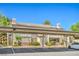 Apartment building featuring covered parking, landscaped greenery, and well-maintained exterior, all under a clear blue sky at 5710 E Tropicana Ave # 1017, Las Vegas, NV 89122