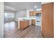 View of kitchen with white appliances, wood cabinets, open floor plan, and vinyl wood floors at 5710 E Tropicana Ave # 1017, Las Vegas, NV 89122