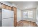 View of the kitchen and dining area, which features wood cabinets, wood floors, and white appliances at 5710 E Tropicana Ave # 1017, Las Vegas, NV 89122