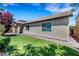 Side view of backyard showcasing healthy lawn and the rear facade of the home with a tile roof at 5713 Silver Cascade Ave, Las Vegas, NV 89131
