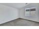 Bedroom features neutral carpet, white walls, base molding, and a window with views of the outdoors at 5713 Silver Cascade Ave, Las Vegas, NV 89131