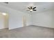 Large bedroom with neutral walls, neutral carpet, ceiling fan, and access to bathroom at 5713 Silver Cascade Ave, Las Vegas, NV 89131