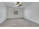 Minimalist bedroom with neutral carpet, white walls, and a ceiling fan at 5713 Silver Cascade Ave, Las Vegas, NV 89131