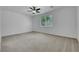 Spacious primary bedroom with plush carpet, large window, and ceiling fan at 5713 Silver Cascade Ave, Las Vegas, NV 89131