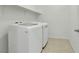 Bright laundry room features white washer and dryer, tile floor, and storage shelf at 5713 Silver Cascade Ave, Las Vegas, NV 89131