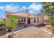 Backyard area with covered patio, decorative rock, and mature desert landscaping at 5900 Red Umber Ave, Las Vegas, NV 89130