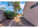 Home's side yard featuring mature landscaping, gravel, and a sidewalk at 5900 Red Umber Ave, Las Vegas, NV 89130