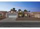 Charming single-story home with a two-car garage and desert landscaping at dusk at 5900 Red Umber Ave, Las Vegas, NV 89130