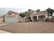 Single story home with desert landscaping, covered porch, dormer windows and a two car garage at 5900 Red Umber Ave, Las Vegas, NV 89130