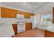 Bright kitchen boasts wood cabinetry, white appliances, tile floors, and natural light at 5900 Red Umber Ave, Las Vegas, NV 89130