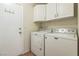 Bright laundry room featuring a stacked washer and dryer and ample white cabinet space at 5900 Red Umber Ave, Las Vegas, NV 89130