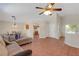 Inviting living room featuring neutral tones, a ceiling fan, tile floors and lots of natural light at 5900 Red Umber Ave, Las Vegas, NV 89130