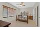 Bedroom with tiled floors, ceiling fan, decorative headboard, side tables, and closed window blinds at 6001 Falconer Ave, Las Vegas, NV 89122