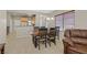 Open-concept dining area with wooden table and chairs, flowing into the kitchen and living spaces at 6001 Falconer Ave, Las Vegas, NV 89122