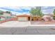 Single-story home with attached garage, mature trees, and low-maintenance rock landscaping at 632 Arrayo Way, Boulder City, NV 89005
