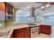 Kitchen view with granite countertops, stainless steel range, and archway to living spaces at 632 Arrayo Way, Boulder City, NV 89005
