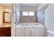 Bathroom showcasing a safe step walk-in tub with shower head and tile surround, next to the vanity at 632 Arrayo Way, Boulder City, NV 89005