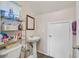 Bathroom with tile floors, pedestal sink, and a white door at 6928 Smiling Cloud Ave, Henderson, NV 89011