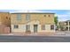 Two-story tan home with a desert landscape and a bench in front at 6928 Smiling Cloud Ave, Henderson, NV 89011
