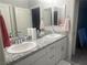 Bathroom featuring double sinks with granite countertops and white cabinets at 7527 Ardenno St, North Las Vegas, NV 89084