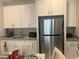Modern kitchen featuring granite countertops, white cabinets, and stainless steel appliances at 7527 Ardenno St, North Las Vegas, NV 89084